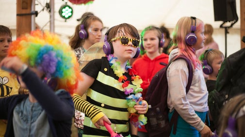 Children dressed in neon clothes and sunglasses at a silent disco
